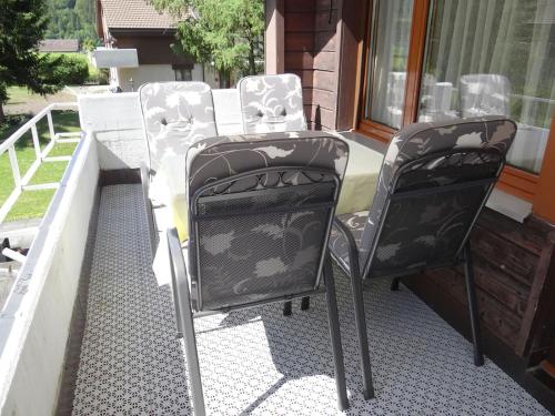a pair of chairs sitting on a porch at Apartment Chalet Bergblick by Interhome in Engelberg