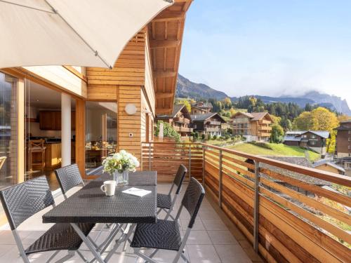 a balcony with a table and chairs with a view at Apartment Am Acher II Apt- F by Interhome in Wengen