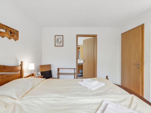 a bedroom with a large bed with two white towels on it at Apartment Am Acher II Apt- F by Interhome in Wengen