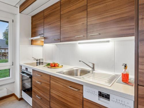 a kitchen with wooden cabinets and a sink at Apartment Residence Apt- 15 by Interhome in Wengen