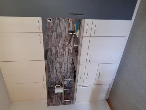 a small bathroom with a shower and white cabinets at Apartment Stöckli Studio by Interhome in Lenk