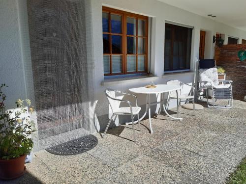 a patio with a table and chairs next to a building at Apartment Stöckli Studio by Interhome in Lenk