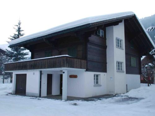 una casa con techo de madera en la nieve en Apartment Elena # 1 by Interhome, en Lenk