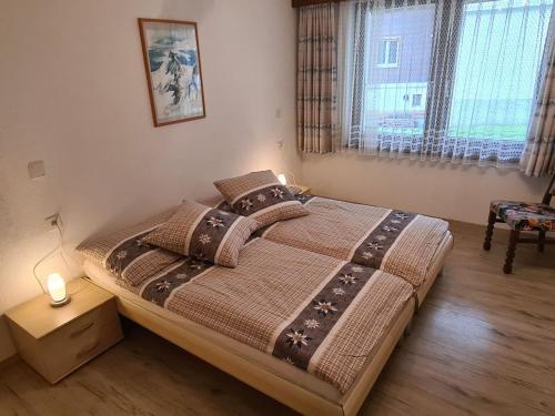a bedroom with a large bed with a lamp on it at Apartment Sunshine by Interhome in Saas-Grund