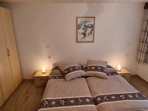 a bedroom with a bed with two candles on it at Apartment Sunshine by Interhome in Saas-Grund