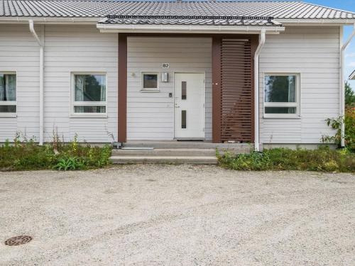 ein weißes Haus mit einer weißen Tür und einer Einfahrt in der Unterkunft Holiday Home 4 seasons b 2 by Interhome in Lahdenperä