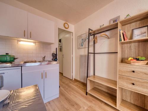  La cuisine est équipée de placards blancs et d'un réfrigérateur. dans l'établissement Studio Vostok Zodiaque-80 by Interhome, au Corbier