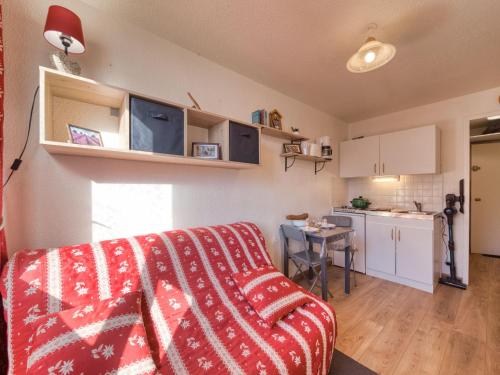 un salon avec un canapé rouge et une cuisine dans l'établissement Studio Vostok Zodiaque-80 by Interhome, au Corbier