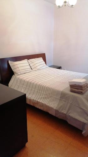 a bedroom with a large bed with white sheets at Madeira property in Câmara de Lobos