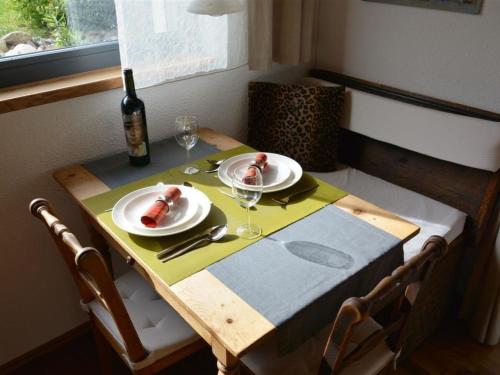 a table with two plates of food and a bottle of wine at Apartment Bolzli-Hus by Interhome in Blankenburg