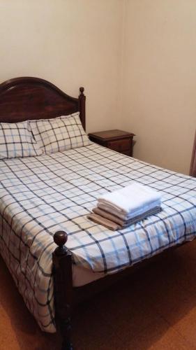 a bedroom with a bed with a blue and white blanket at Madeira property in Câmara de Lobos