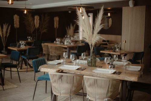a restaurant with wooden tables and chairs and a table with wine glasses at Camping Del Mar 64, Mobile Home Premium, 2 chambres, 4 personnes, 1 Salles de Bain, bord de mer in Argelès-sur-Mer
