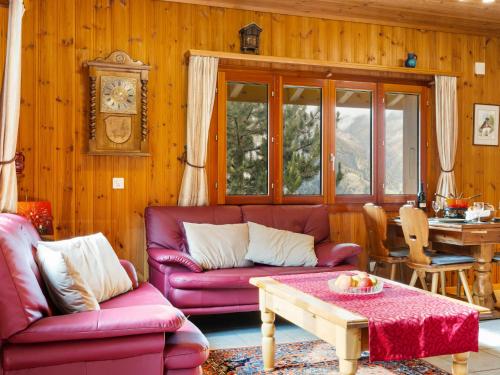 a living room with red couches and a table at Chalet Als man zählte 1989 by Interhome in Gasenried