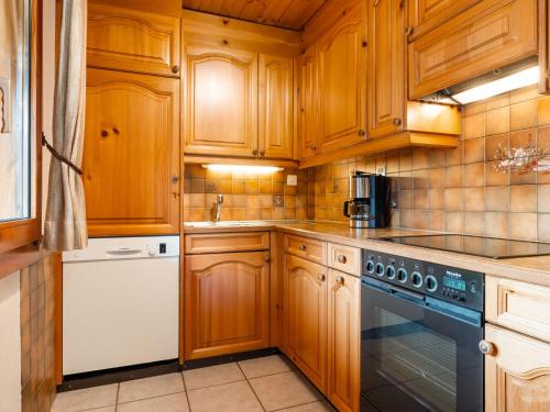 a kitchen with wooden cabinets and a dishwasher at Chalet Als man zählte 1989 by Interhome in Gasenried