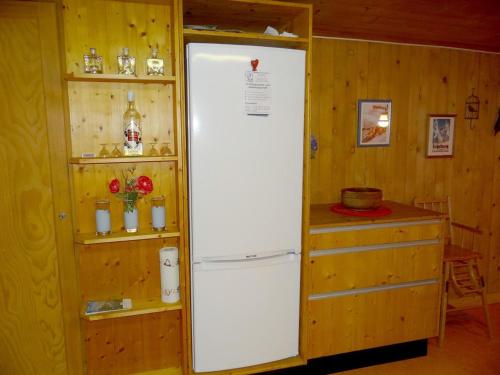 a white refrigerator in a room with a shelf at Apartment Steinacher 7 by Interhome in Engelberg