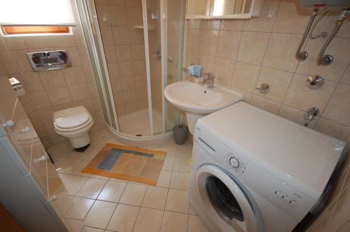 łazienka z pralką i umywalką w obiekcie Apartment Grozic w mieście Porat
