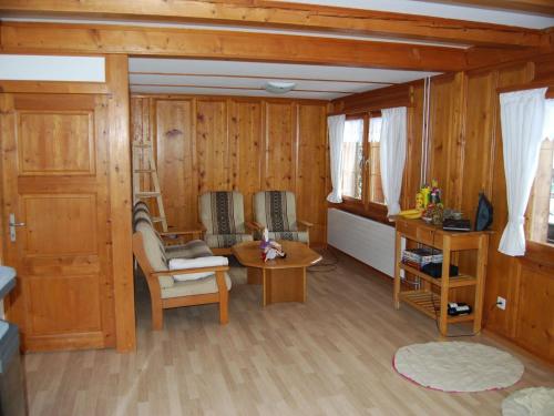 a living room with wooden walls and a table at Apartment Ferienhaus Niesen View by Interhome in Erlenbach im Simmental
