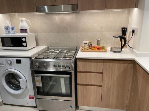 une cuisine équipée d'une cuisinière et d'un micro-ondes dans l'établissement Cozy zone, à Charjah