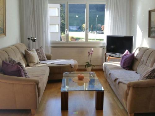 a living room with two couches and a tv at Apartment Alpenstrasse 621 by Interhome in Engelberg