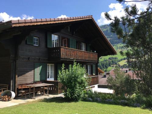 a large wooden house with a picnic table in front of it at Apartment Chriba by Interhome in Lenk