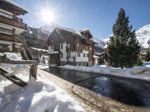 a house in the snow next to a river at Apartment Maria by Interhome in Saas-Fee