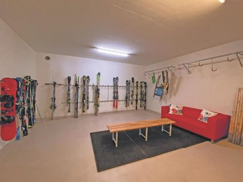 a room with skis on the wall and a red couch at Apartment Liebrand by Interhome in Churwalden
