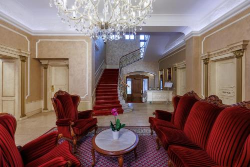 a living room with red chairs and a chandelier at Pension U Golfu Cihelny in Karlovy Vary