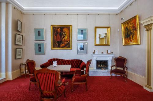 a room with a table and chairs and a fireplace at Pension U Golfu Cihelny in Karlovy Vary