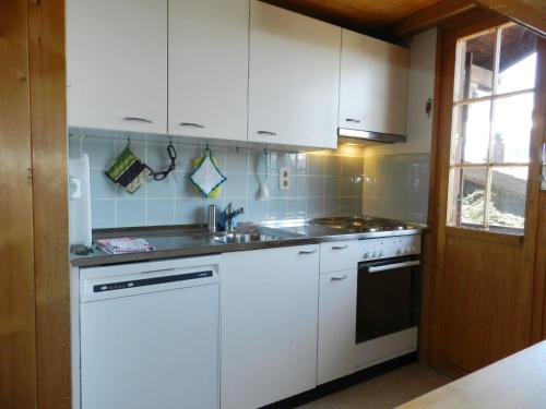 a kitchen with white cabinets and a sink at Apartment Guex by Interhome in Hornkessel
