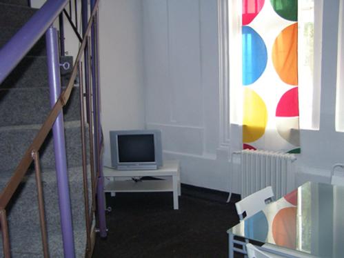 een woonkamer met een tv op een tafel bij Hostel Praha Ládví in Praag