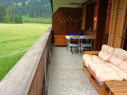 a porch with couches and tables and chairs on a house at Apartment Chalet Lerchweid Lenk by Interhome in Lenk