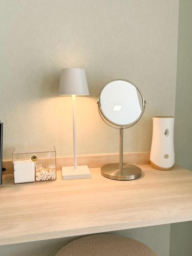 a desk with a mirror and a lamp on it at Vuela Casa 2 in North Pattaya
