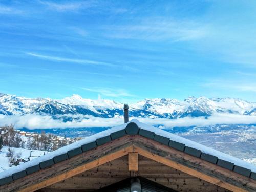 uma vista para as montanhas cobertas de neve a partir do telhado de uma cabana em Chalet Mirabeau 8 by Interhome em Nendaz