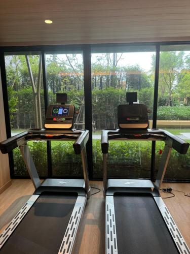 een fitnessruimte met twee loopbanden voor een raam bij Vuela Casa 2 in Noord Pattaya