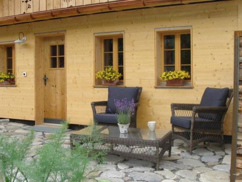 two chairs and a table in front of a house at Apartment Gwunderstübli by Interhome in Lenk