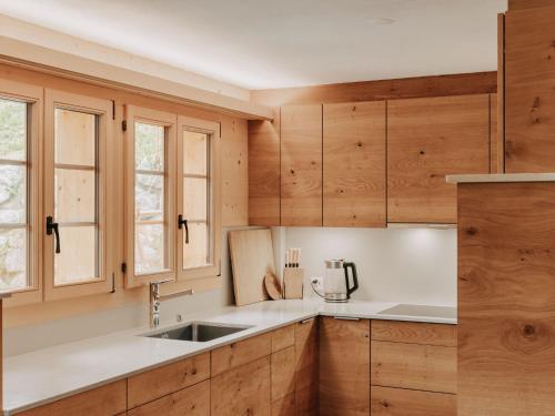 a kitchen with wooden cabinets and a sink at Apartment Giferblick by Interhome in Gstaad