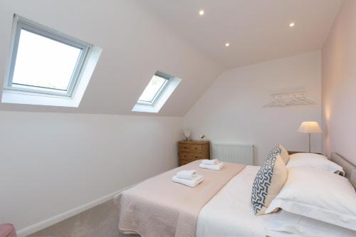 a bedroom with a bed with two windows at The Caradoc in Shrewsbury