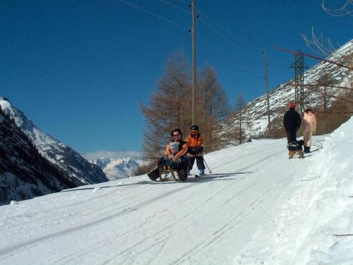 a group of people sitting on a snow covered slope at Apartment Haus Alpenrose by Interhome in Saas-Almagell