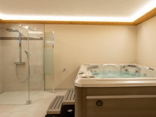 a bathroom with a tub and a shower at Apartment Haus Alpenrose by Interhome in Saas-Almagell