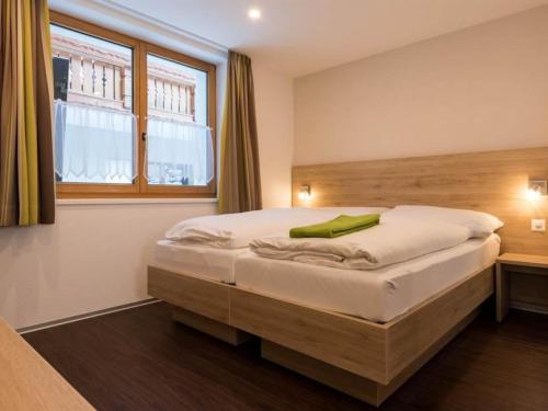a bedroom with a large bed with a window at Apartment Haus Alpenrose by Interhome in Saas-Almagell