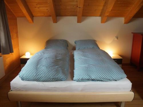two pillows sitting on a bed in a room at Apartment Lischenhaus 2 - Wohnung Flösch by Interhome in Lenk
