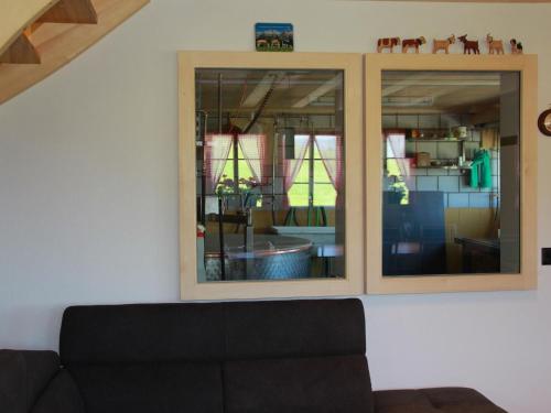 a living room with two mirrors on the wall at Apartment Alphaus Hasler by Interhome in Gummeli