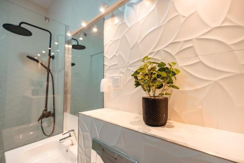 a bathroom with a potted plant sitting on a counter at Blvd Ivory Pipera ap 60A in Voluntari