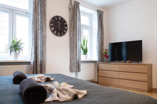 a bedroom with a bed with a clock and a dresser at revLIVING Apartments Eggenburg in Eggenburg