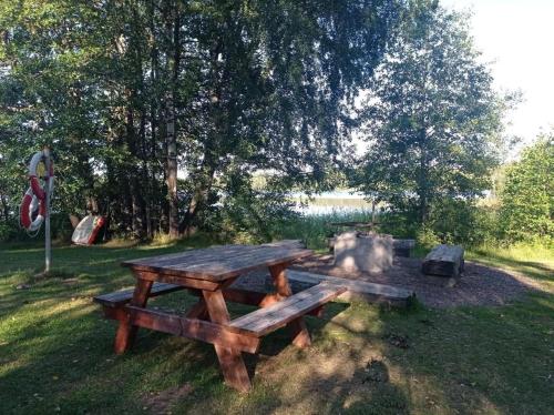 a picnic table in the grass near a lake at Cozy Forest View Villa with 5 Bedrooms in Jönköping