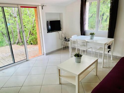 Μια τηλεόραση ή/και κέντρο ψυχαγωγίας στο Appartement dans un coin de paradis avec piscine