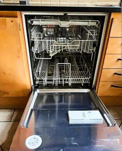 an open dishwasher with a white appliance in it at Cozy Forest View Villa with 5 Bedrooms in Jönköping