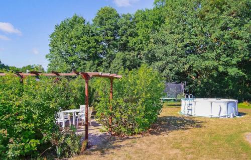 a garden with a wooden pergola and bushes at Ferienwohnung Groß Plasten in Groß Plasten
