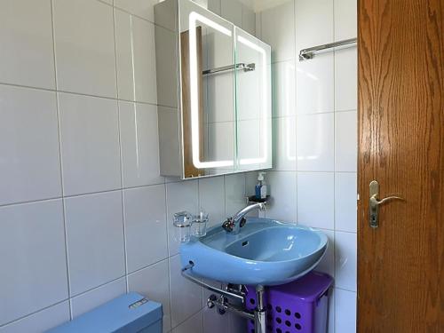 a bathroom with a blue sink and a mirror at Apartment Dorfstrasse 53c by Interhome in Engelberg