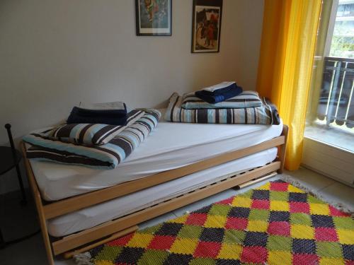 two twin beds in a room with a window at Apartment Dorfstrasse 53c by Interhome in Engelberg